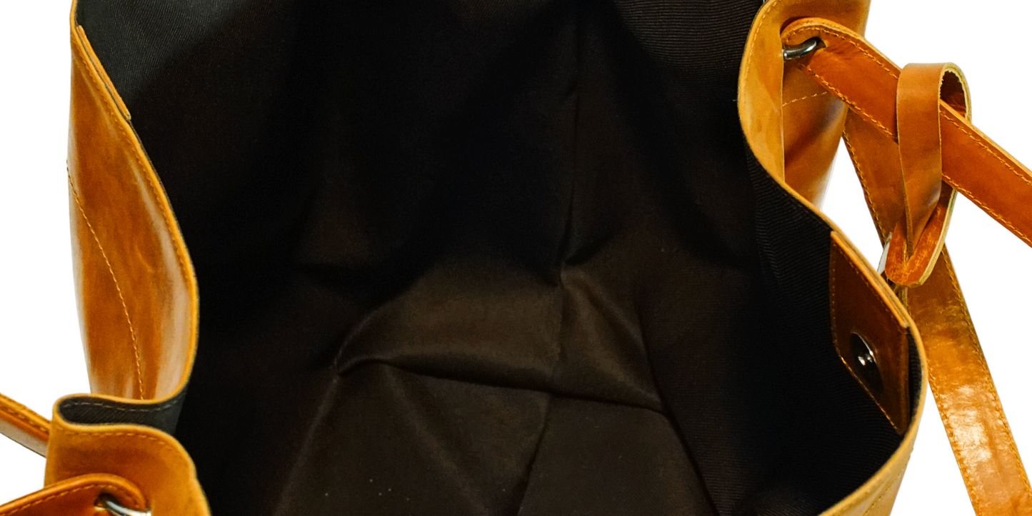 Close-up of a brown leather bag with a strap on a white background