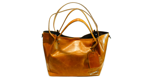 Brown leather handbag with a tag on a white background